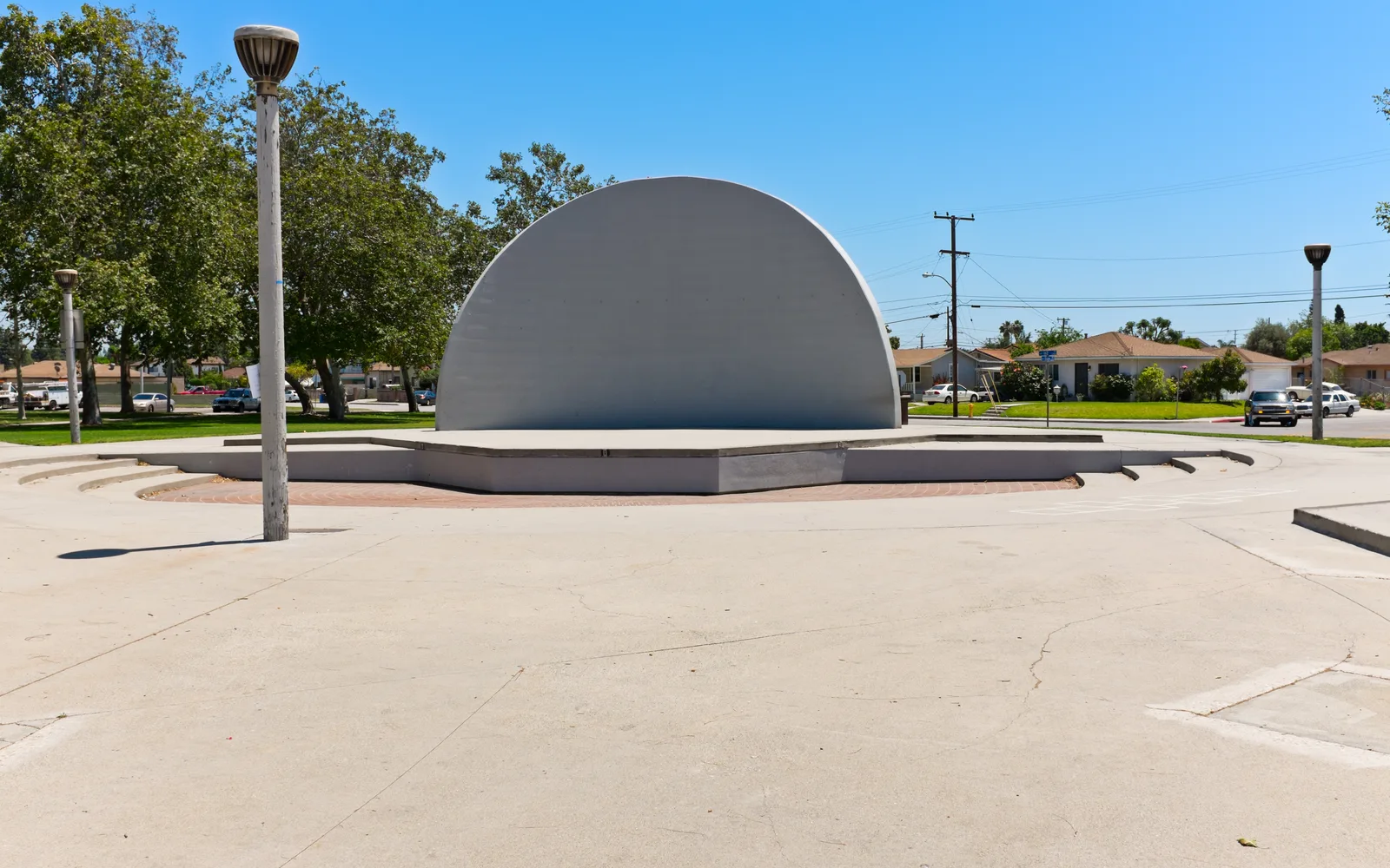 An outdoor amphitheater seating area surrounded by lights and structures, ready for evening performances